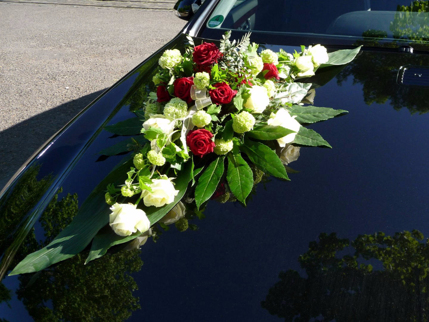 Ausschweifendes Autobukett mit weißen und roten Blumen
