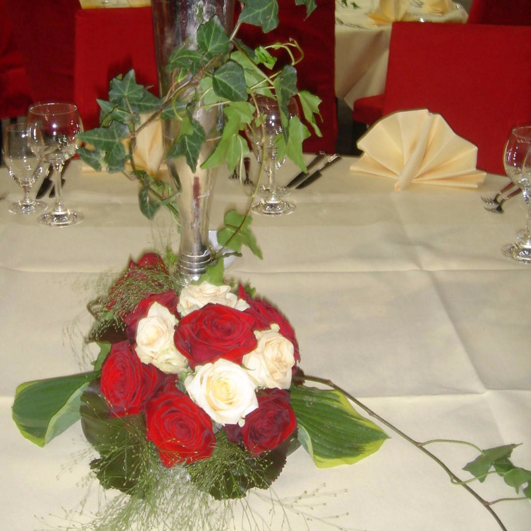Kleines Tischgesteck aus roten und weißen Blumen
